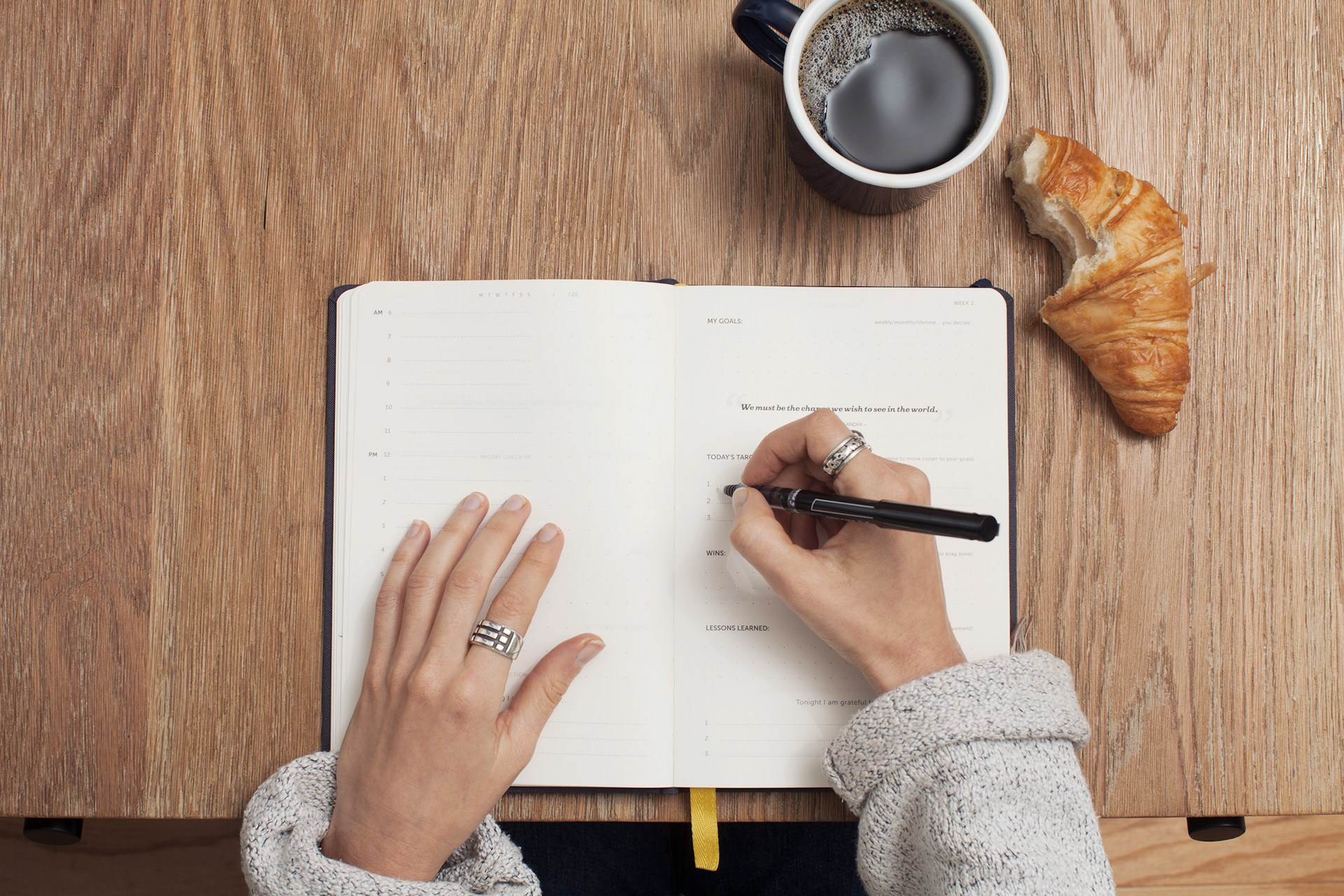 Planning daily health goals with coffee and croissant – a mindful wellness routine